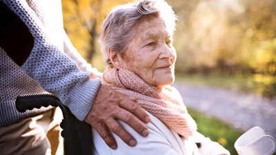 home care business in West Midlands and Walsall elderly woman in wheelchair outside in autumnal park